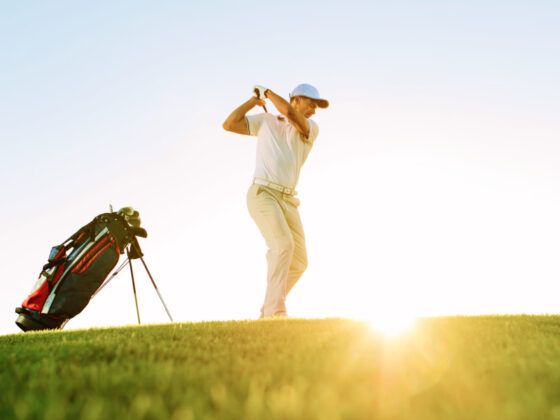 Golfer doing a golf stroke in the sun in Mallorca