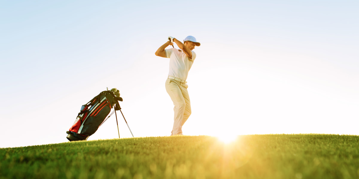 Golfer doing a golf stroke in the sun in Mallorca