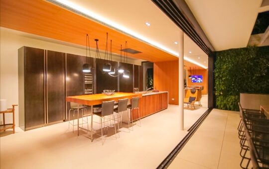 Luxusvilla auf Monport - Blick auf die Küche bei geöffneten Panoramafenstern